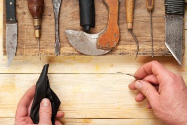 Deri el sanatları araçları ahşap arka plan üzerinde. Craftmans işçiliği DIY araçları kullanarak deri ile çalışma. Çalışma tablosu gizle ve çalışma el yapımı araçları parçası. Üstten Görünüm. Kopya alanı