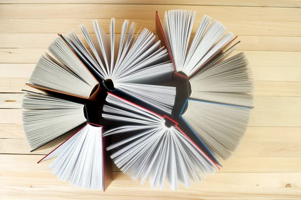 Öppen bok, trave inbundna böcker på bord. — Stockfoto