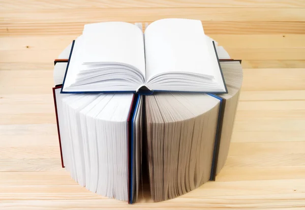 Libro aperto, pila di libri rigidi su tavolo di legno . — Foto Stock