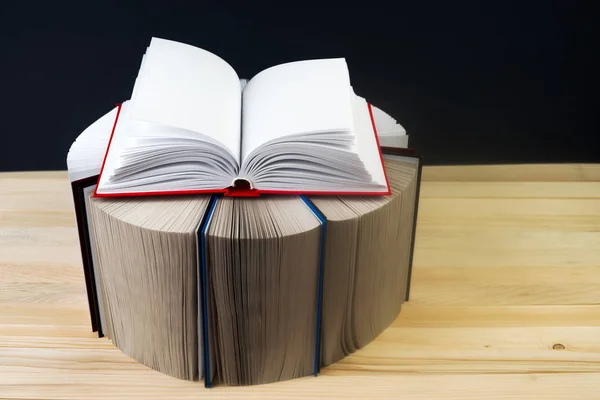 Livro aberto, pilha de livros de capa dura em mesa de madeira . — Fotografia de Stock