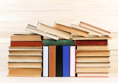 Ahşap masa üzerinde ciltli kitap yığını. Okula dönüş.