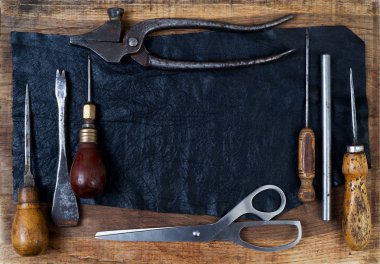 Deri el sanatları araçları ahşap arka plan üzerinde. Craftmans çalışma masası.