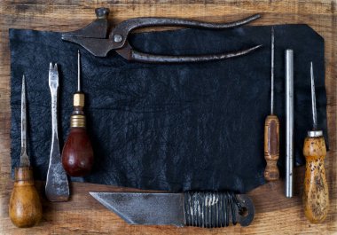 Deri el sanatları araçları ahşap arka plan üzerinde. Craftmans çalışma masası.