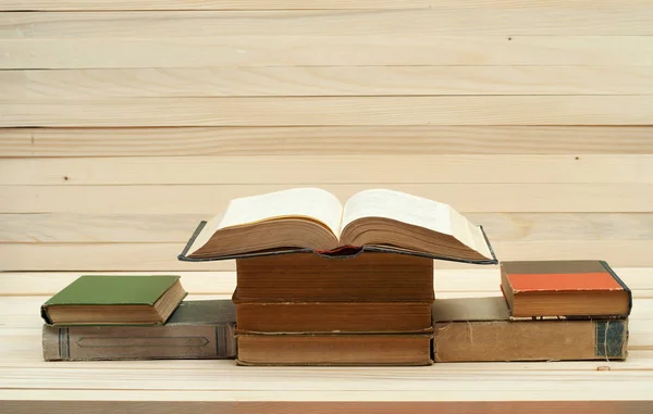 Montón de libros. Libro abierto, libros de tapa dura sobre mesa de madera. El conocimiento es importante. Copiar espacio. Vista superior — Foto de Stock