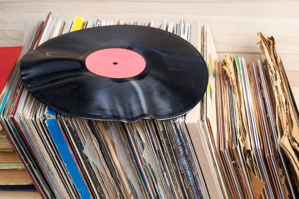 Retro style image of a collection of old vinyl record lp 's with sleeves on a wooden background. Просматриваю коллекцию виниловых пластинок. Музыкальный фон Копирование пространства — стоковое фото