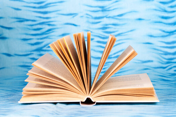 Old and used hardback books or text books on wooden table. Books and reading are essential for self improvement, gaining knowledge and success in our careers, business and personal lives. Copy space