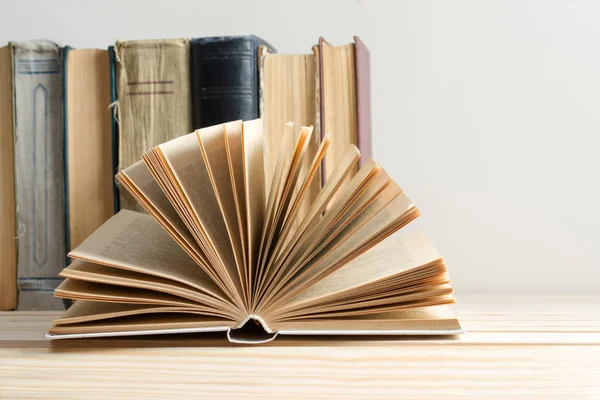 Libro abierto, pila de libros de tapa dura en la mesa . — Foto de Stock