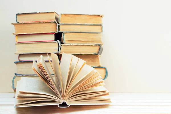 Libro abierto, pila de libros de tapa dura en la mesa . — Foto de Stock