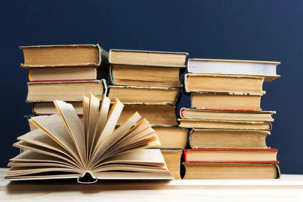 Libro abierto, pila de libros de tapa dura en la mesa . — Foto de Stock