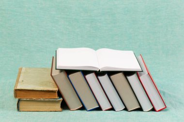 Açık kitap, masada ciltli kitap yığını. Okula dönüş. Kopya alanı