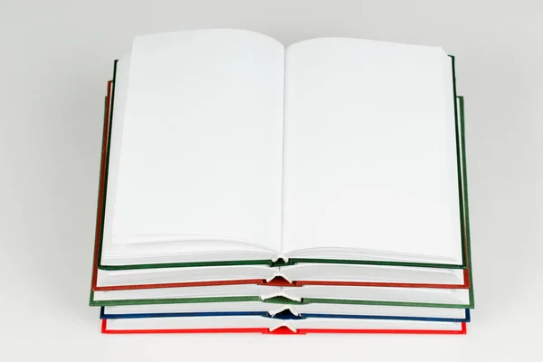 Open book, stack of hardback books on table. — Stock Photo, Image