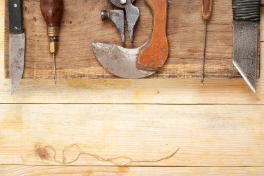 Deri el sanatları araçları ahşap arka plan üzerinde. Craftmans çalışma masası. Çalışma tablosu gizle ve çalışma el yapımı araçları parçası. Üstten Görünüm