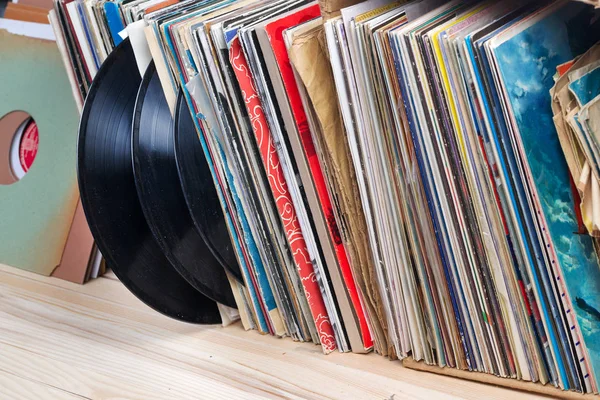 Immagine in stile retrò di una collezione di vecchi LP in vinile con maniche su uno sfondo di legno. Copia spazio — Foto Stock