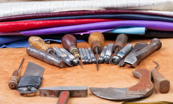 Leather craft tools on a leather background. Craftsman work desk . Piece of hide and working handmade tools on a work table. Top view. Copy space — Stock Photo, Image