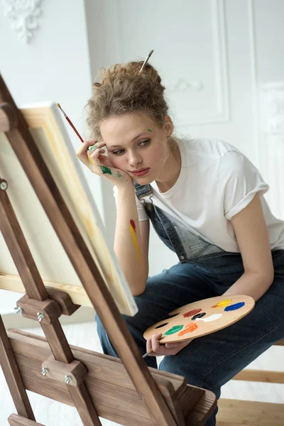 Жінка малює картину на полотні з олійними фарбами у своїй студії — стокове фото