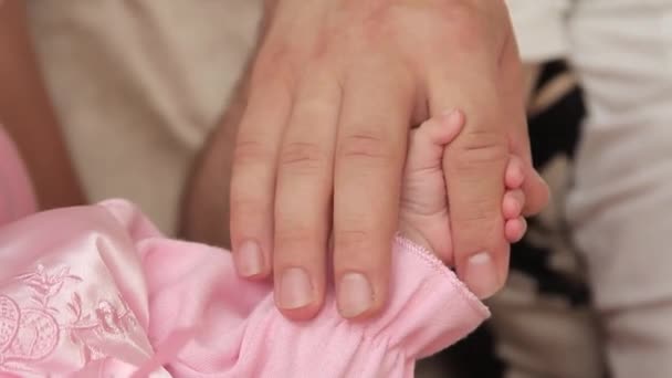 Девочка держит отца за палец. — стоковое видео