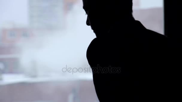 Silhouet van een man voor het raam — Stockvideo