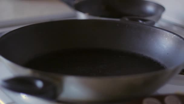 Hausfrau gießt Öl in die Pfanne — Stockvideo