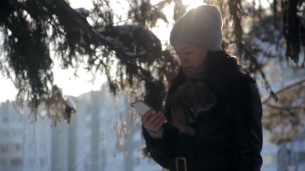 Menina escreve SMS na floresta de inverno — Vídeo de Stock