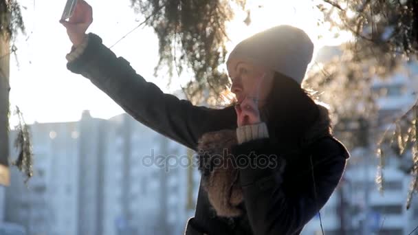 Menina alegre faz selfi durante o pôr do sol na cidade de inverno — Vídeo de Stock