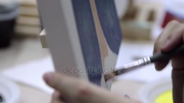 Sanatçı darbeleri tuval üzerinde yapar.