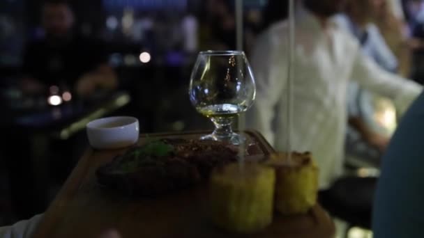 El camarero trae una copa de coñac — Vídeos de Stock