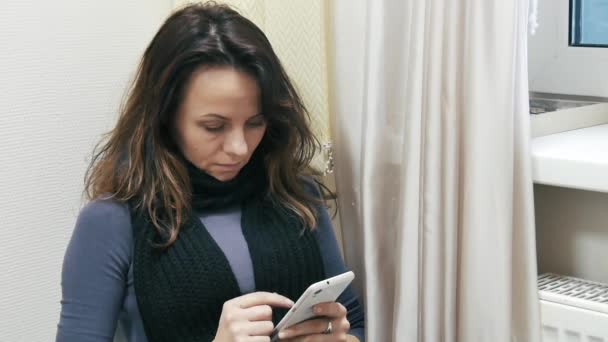 Menina lê uma mensagem no telefone — Vídeo de Stock