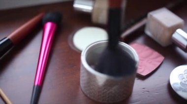 Kız makyaj için toz fırça alır