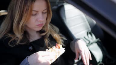 Kız arabada pizza yemek