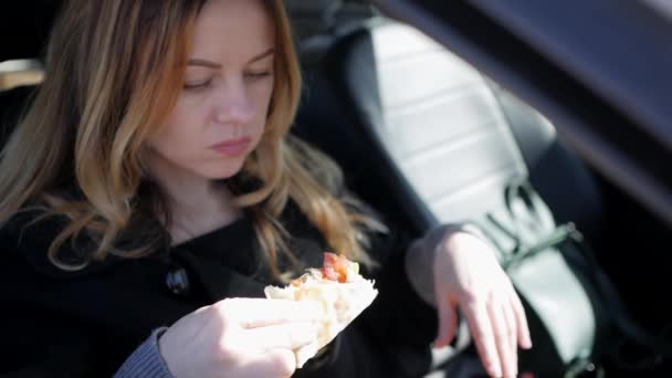 Fille manger de la pizza dans la voiture — Video