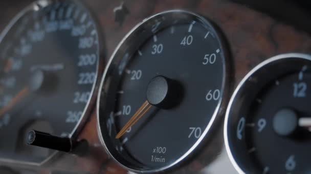 De pijlen op de snelheidsmeter bewegen van het aanzetten van de auto 's motor — Stockvideo