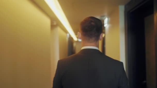 A man in a business suit walks down the hallway — Stock Video