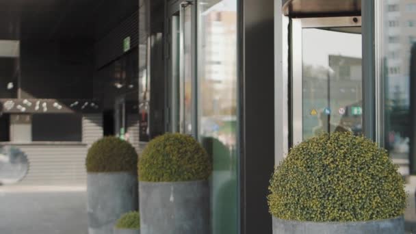 Zakenman loopt de hoteldeur uit voor een wandeling in de stad — Stockvideo