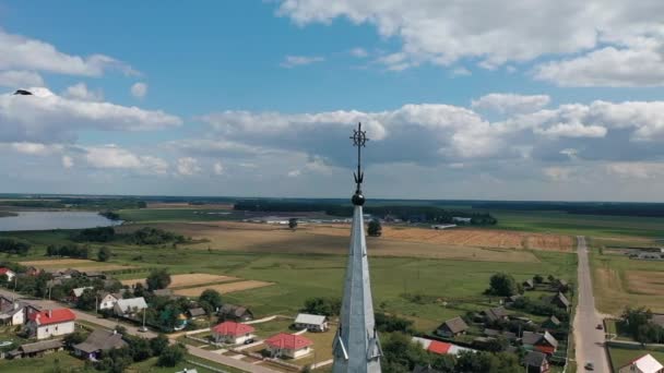 Беспилотник летает вокруг готического храма на фоне живописной сельской местности Беларуси — стоковое видео