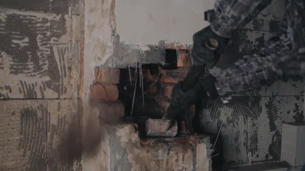 Человек ломает кирпичную стену кувалдой — стоковое видео
