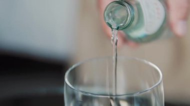 Su şişeden cama dökülür.