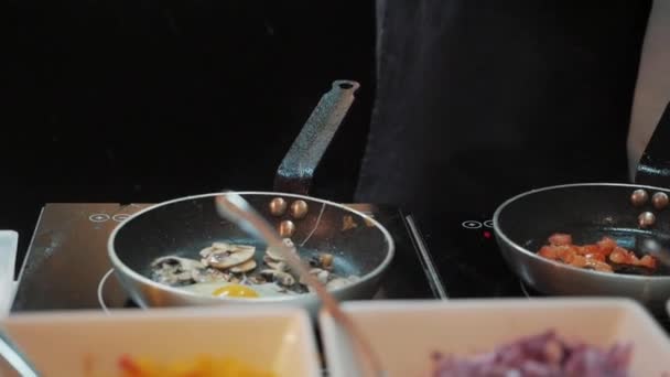 El cocinero tuesta los huevos revueltos en una sartén — Vídeo de stock