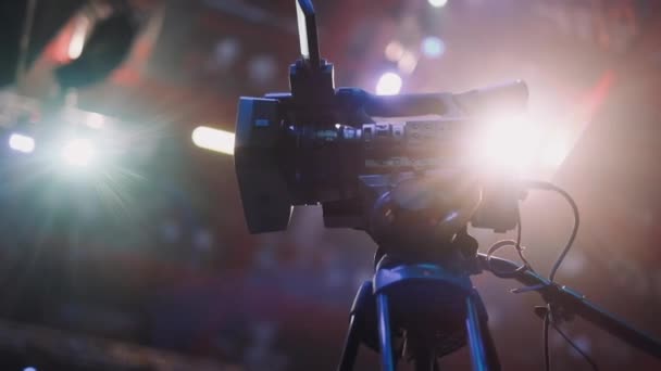 Профессиональная видеокамера стоит на штативе перед началом большого события — стоковое видео