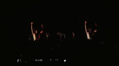 Kalabalık konserde dans ediyor. Bir sürü spot ışığı