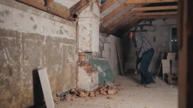 Adam balyozla tuğla duvarı kırıyor.