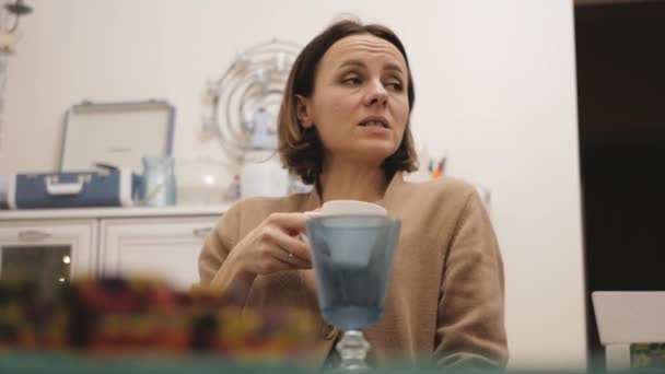 Menina bebe café de uma xícara e conversa com amigos — Vídeo de Stock