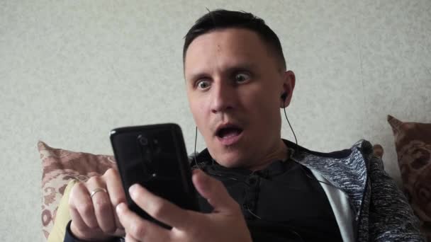 Der Mann ist schockiert von dem, was er auf seinem Smartphone gesehen hat — Stockvideo