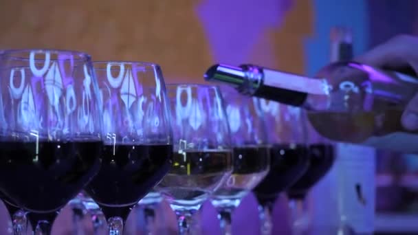 Ο σερβιτόρος ρίχνει κρασί σε ποτήρια κρασιού. — Αρχείο Βίντεο