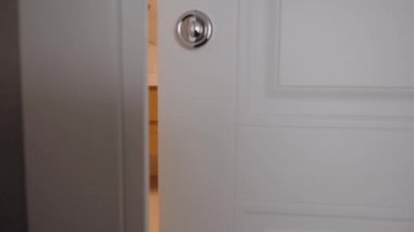 Kamera, banyonun açık kapısının arkasından yavaşça ileri doğru hareket ediyor.