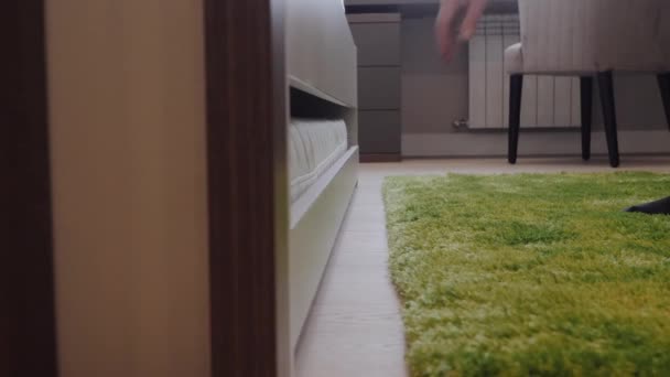 De man haalt een extra matras uit het kinderbed. — Stockvideo