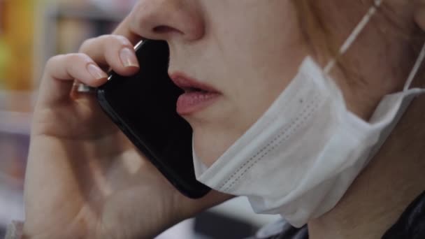 Een zakenvrouw met een beschermend masker communiceert in een winkelcentrum — Stockvideo