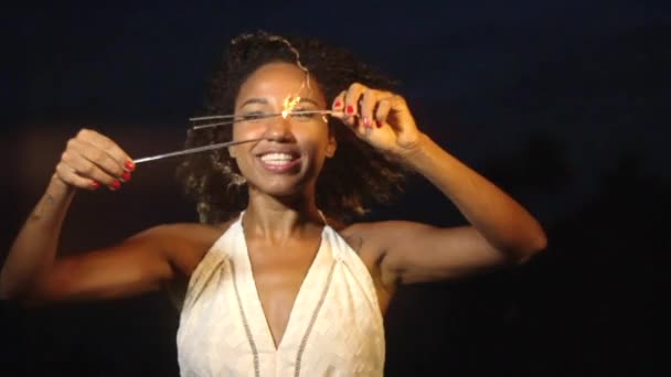 Woman blowing on sparklers at night — Stock Video