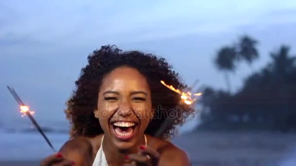 Mujer joven bailando con bengalas en la playa — Vídeo de stock