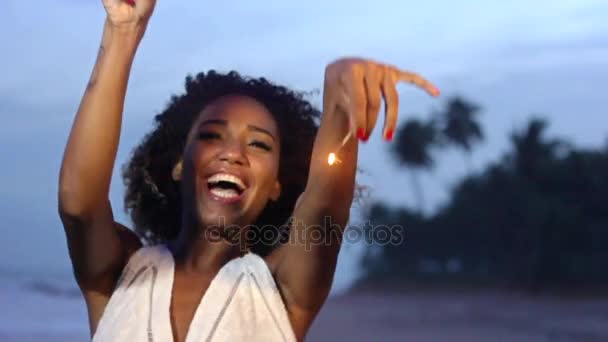 Ung kvinna dansar med tomtebloss på stranden — Stockvideo