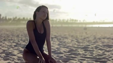 Kumsalda oturuyor ve saç ile oynayan kadın